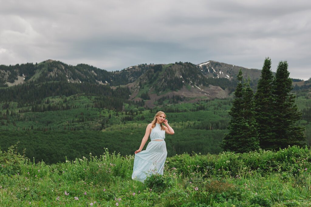 High school senior girl wearing a floral dress, posing for senior portraits at Guardsman Pass in Park City Utah by Austin Texas photographer.