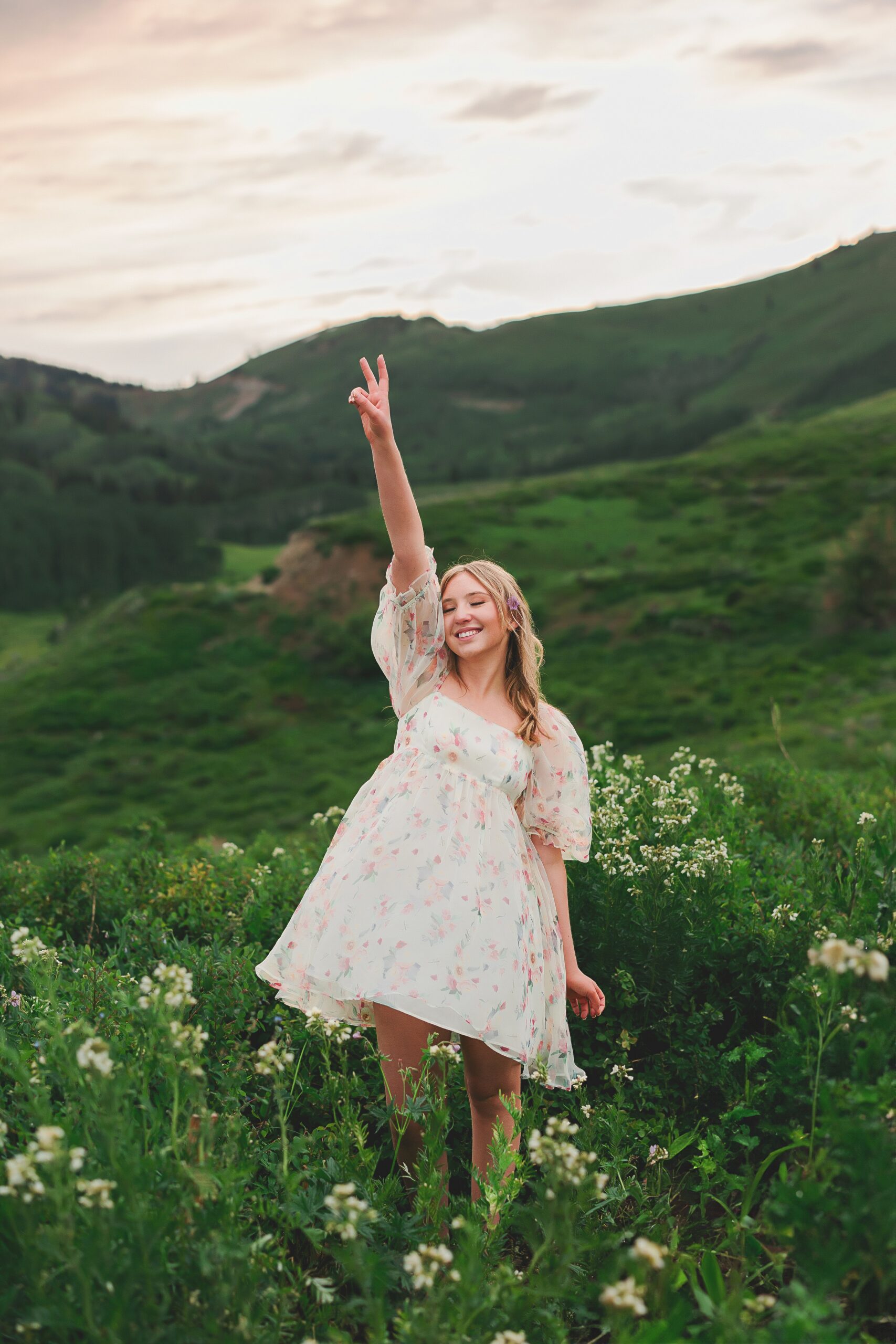 High school senior girl wearing a floral dress, posing for senior portraits at Guardsman Pass in Park City Utah by Austin Texas photographer.